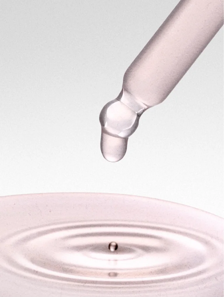 Sakara Cell Reset liquid fulvic acid shown in glass dropper with light pink liquid dispensing above ripple surface, wild blueberry-lemon flavor, 1 fl oz (30 mL), dietary supplement.