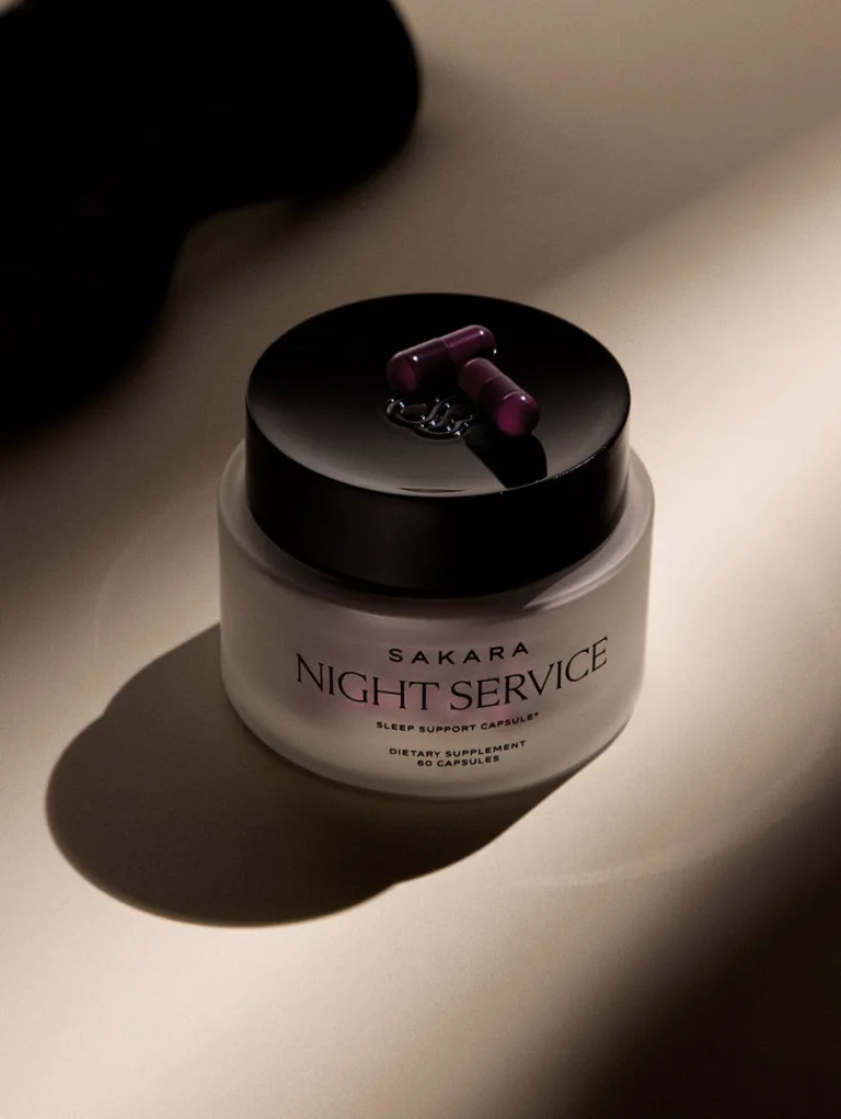 Sakara Night Service in a frosted jar with black lid displayed with two purple capsules placed on top.